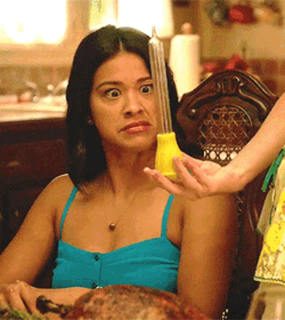 a woman in a blue tank top sits at a table