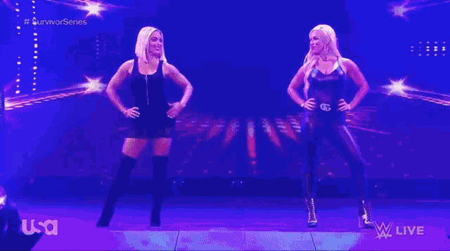 two women are flexing their muscles on a stage in front of a screen that says usa