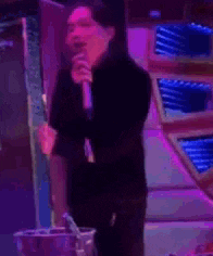 a man is singing into a microphone in a karaoke bar .