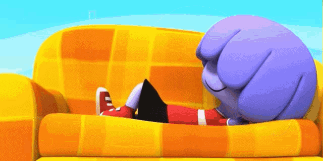 a cartoon character is laying on a yellow couch using a tablet computer .