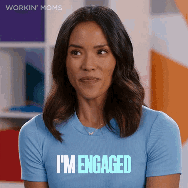 a woman wearing a blue shirt that says " i 'm engaged "