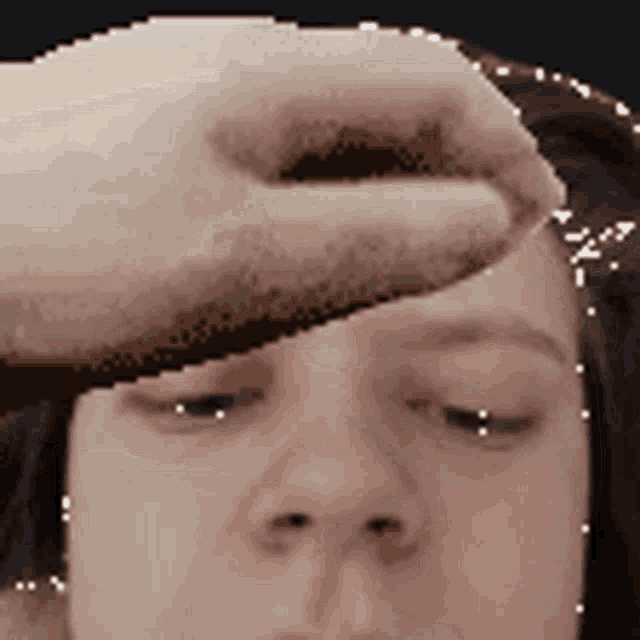 a person is touching a woman 's forehead with their finger .