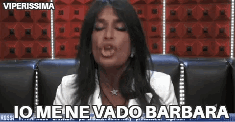 a woman is sitting in a chair with her eyes closed and the words io mene vado barbara above her .