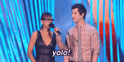 a man and a woman are standing next to each other on a stage . the woman is holding a microphone .