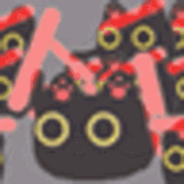 a blurred image of a black cat with yellow ribbons around its head .