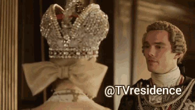 a man wearing a wig and a crown looks at a woman wearing a crown with the words @tvresidence below him