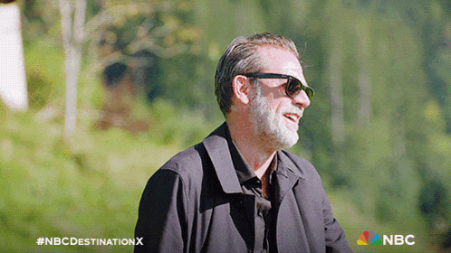 a man wearing sunglasses and a black jacket with the nbc destination x logo