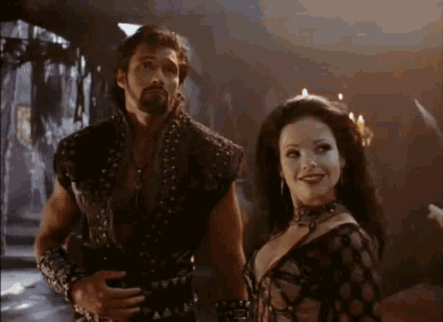 a man and a woman are standing next to each other in a dark room