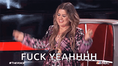 a woman is sitting in a chair with her arms outstretched and the words " fuck yeahhhh " on the screen behind her .