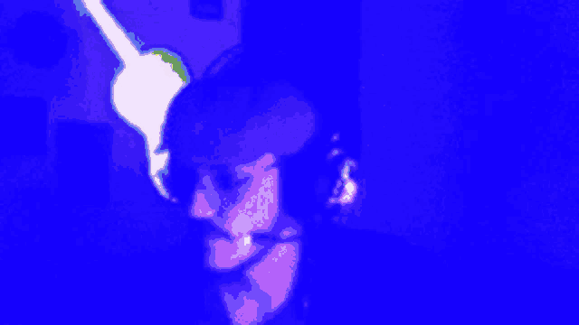 a blurry picture of a man wearing headphones in a blue light