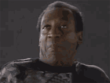 a close up of a man 's face making a funny face while wearing a black shirt .