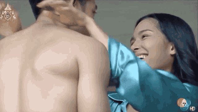 a man and a woman are hugging each other and smiling .