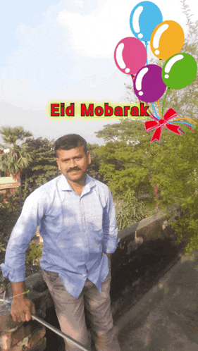 a man in a blue shirt stands in front of balloons and the words eid mobarak