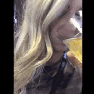 a woman with blonde hair is drinking from a cup