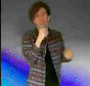 a blurry picture of a man wearing ear buds and a striped jacket