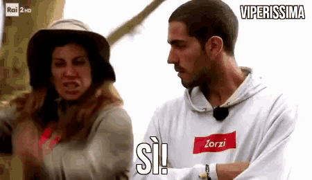 a man and a woman are standing next to each other and the man is wearing a white sweatshirt with the word zorzi on it