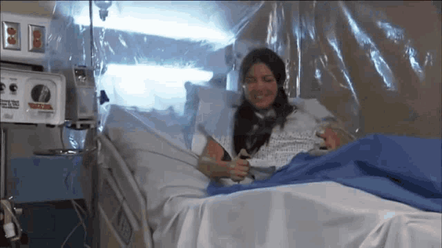 a woman laying in a hospital bed with a sign that says texas