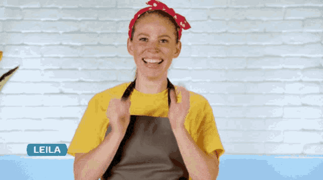 a woman wearing an apron and a yellow shirt is called leila