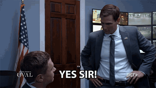 a man in a suit says yes sir in front of another man