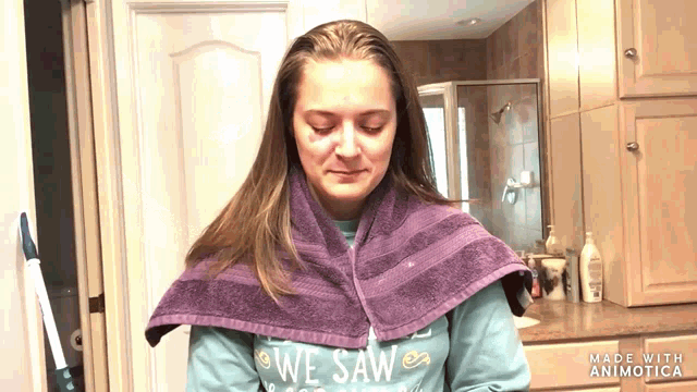 a woman with a purple towel wrapped around her neck is wearing a shirt that says we saw