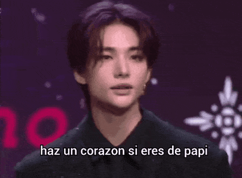 a young man is making a heart shape with his hands and says `` haz un corazón si eres de papi '' .