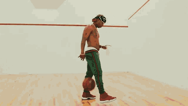 a man without a shirt is holding a basketball