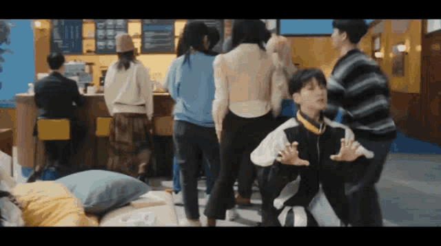 a group of people are dancing in front of a counter