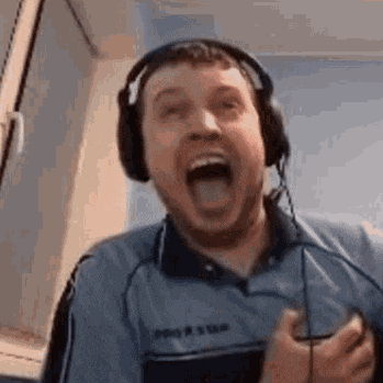 a man wearing headphones is making a funny face while holding a microphone .