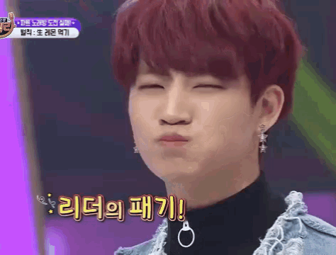 a young man with red hair is making a funny face while wearing earrings and a black shirt .