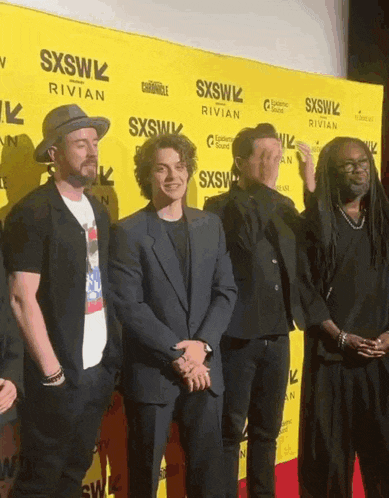 a group of men standing in front of a sxsw sign