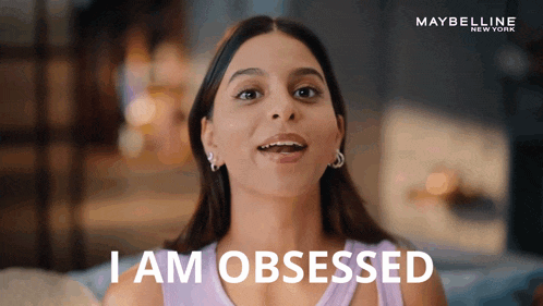 a woman says " i am obsessed " in front of a maybelline ad