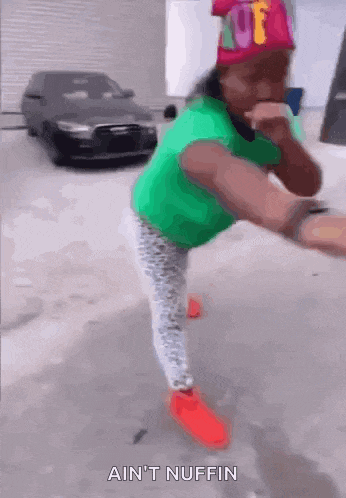 a girl in a green shirt and red shoes is standing on one leg with the words ain 't nuffin above her