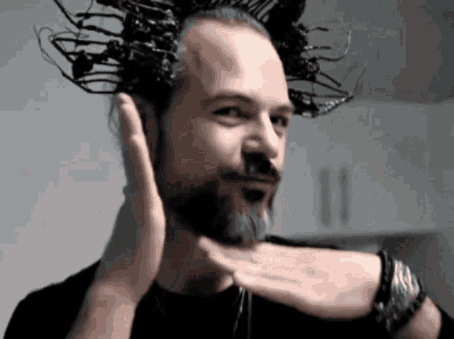 a man with a beard is covering his ears with his hand