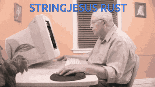 an older man sits at a desk using a computer with stringjesus rust written in blue