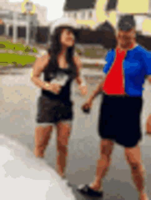 a man and a woman are standing next to each other on a street .