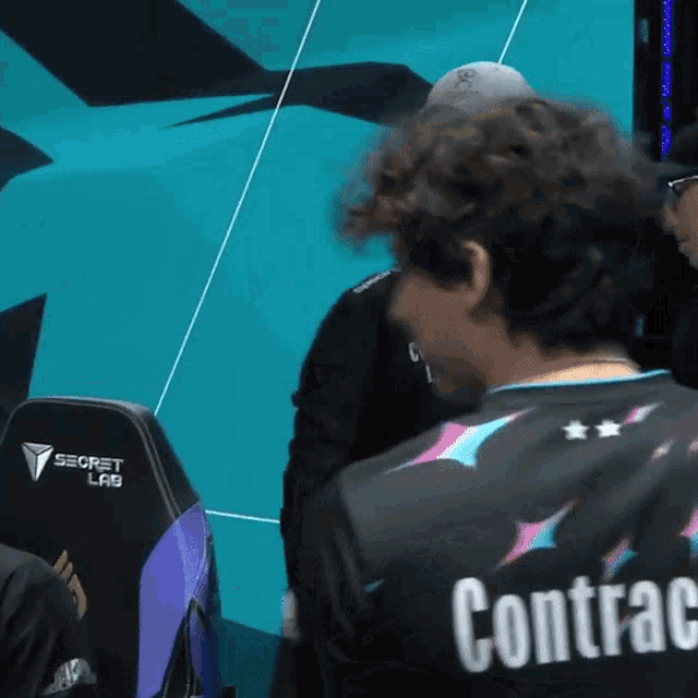 a man in a black shirt that says contrac on the back