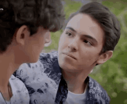 two young men are looking at each other in a close up of their faces .
