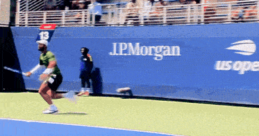 a tennis player is running towards a wall that says jpmorgan us open