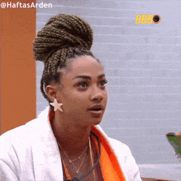 a woman with braids in a bun looks at the camera with the hashtag haftasarden on the bottom
