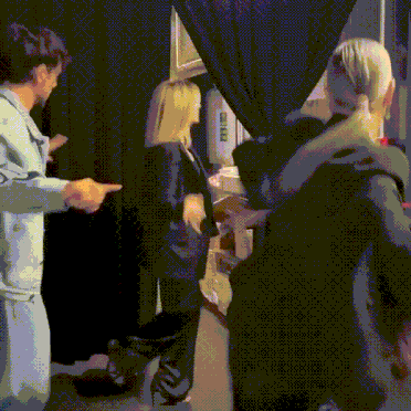 a group of people are standing in front of a black curtain with a sign on it that says ' a & a '