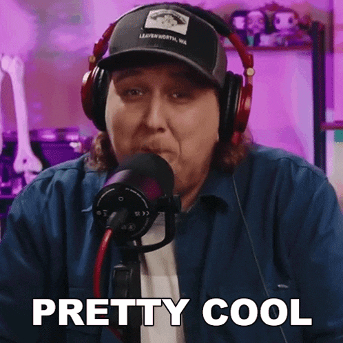 a woman wearing headphones and a hat says " pretty cool " in front of a microphone
