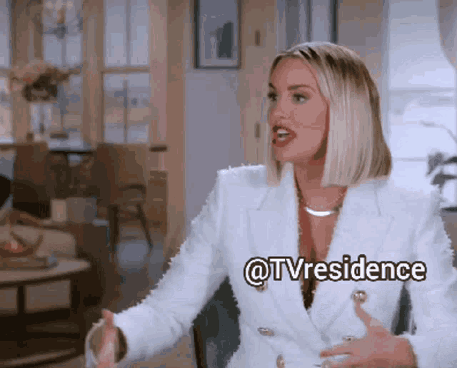 a woman in a white suit is sitting in a chair with a caption that says @tvresidence .