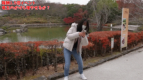 a woman wearing a face mask is standing in front of a lake .