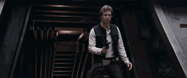 han solo is holding a gun in a dark hallway