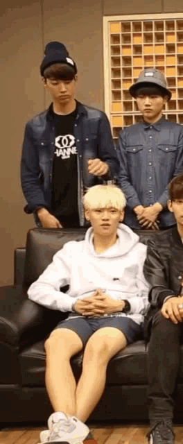 a group of young men are sitting on a couch and one of them is wearing a shirt that says tnt