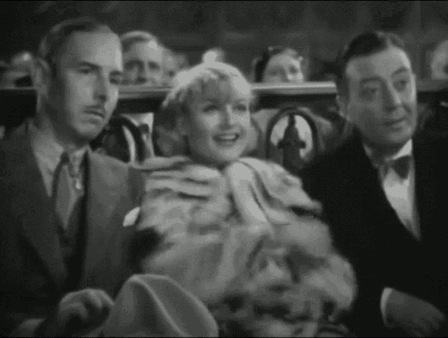 a group of people sitting in a theater watching a movie