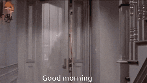 a woman in a white dress is holding a doll and saying good morning