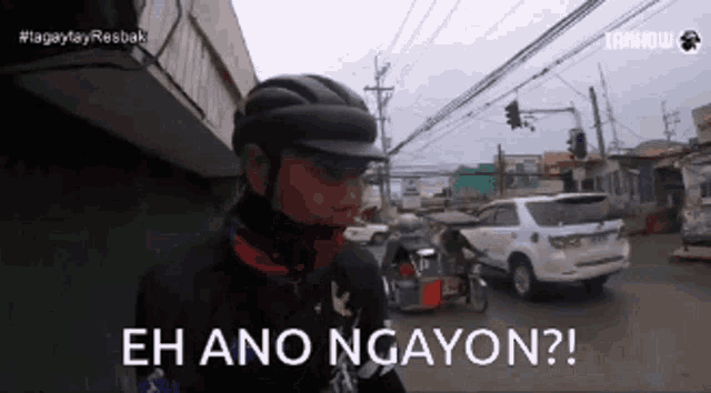 a man wearing a helmet says eh ano ngayon on a street