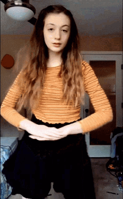 a girl in a yellow striped shirt and black skirt