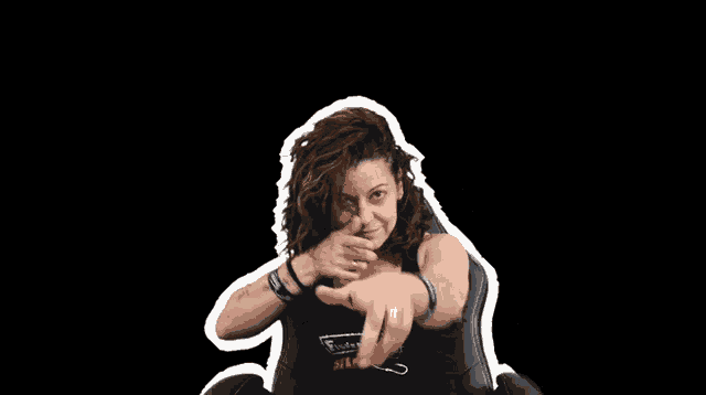 a woman in a black tank top is sitting in a chair and making a funny face